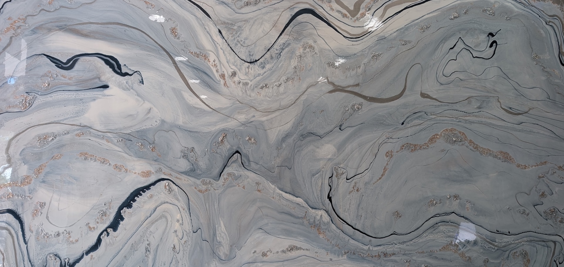 Abstract painting with swirling patterns in shades of gray, white, black, and hints of copper. The lines and colors blend and flow in a marbled effect, creating a fluid, dynamic texture across the canvas.