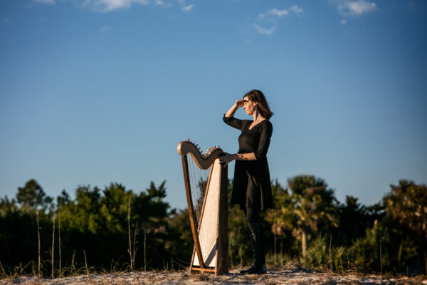 woman playing harp on beach