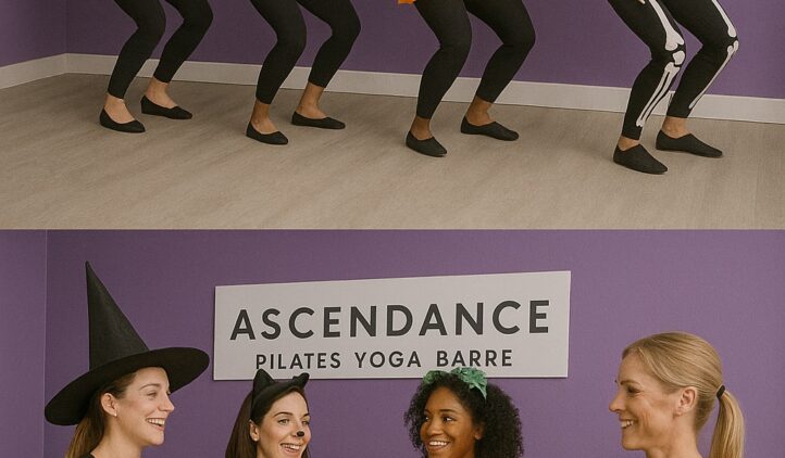 Four women in Halloween costumes (witch, cat, pumpkin, skeleton) pose and dance in a studio with a sign reading Ascendance Pilates Yoga Barre. They then toast with drinks, smiling and celebrating together.