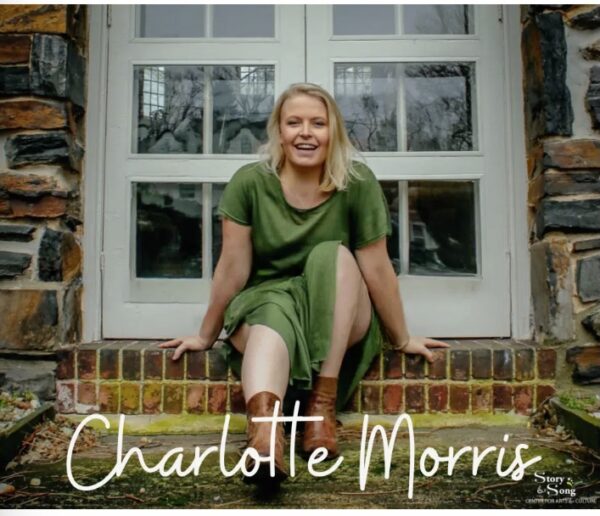 A woman in a green dress and brown boots sits smiling on brick steps in front of a glass door. The name Charlotte Morris is written in white script at the bottom of the image.
