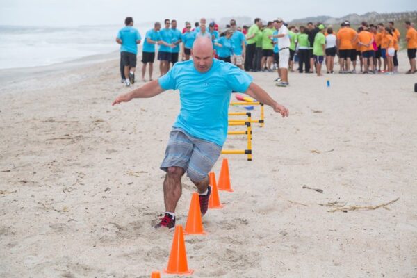 male running beach obstacle course