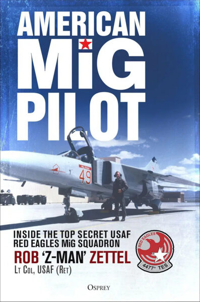 Book cover showing a pilot standing by a MiG jet. Title: American MiG Pilot. Subtitle: Inside the Top Secret USAF Red Eagles MiG Squadron. Author: Rob Z-Man Zettel, Lt Col, USAF (Ret). Red Eagles squadron badge pictured.