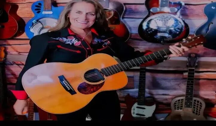 A woman holding a guitar.