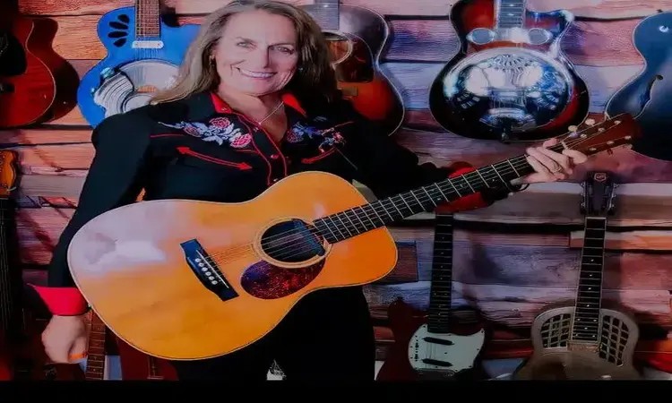 A woman holding a guitar.