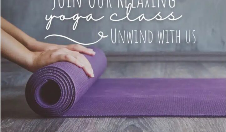 A person’s hands roll out a purple yoga mat on a wooden floor. White text above reads: Join Our Relaxing Yoga Class. Unwind with us. The scene feels calm and inviting.