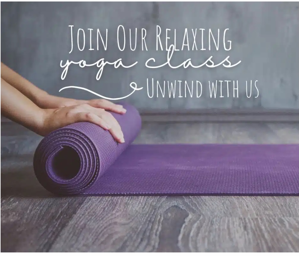 A person’s hands roll out a purple yoga mat on a wooden floor. White text above reads: Join Our Relaxing Yoga Class. Unwind with us. The scene feels calm and inviting.