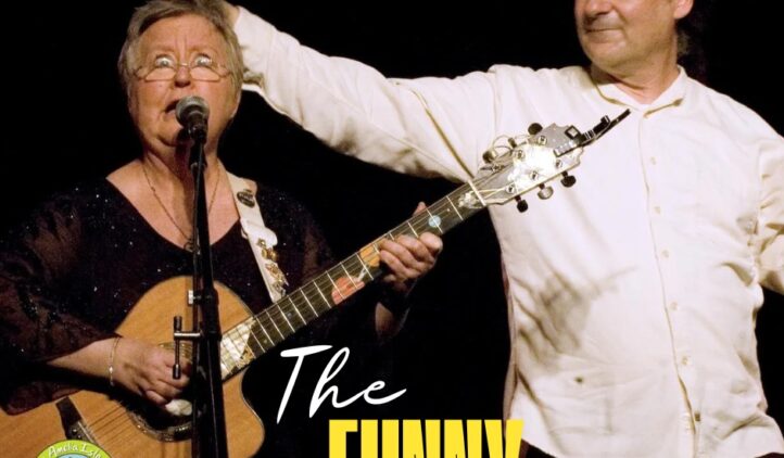 A woman plays guitar and sings into a microphone while a man beside her playfully pats her head. The text reads, The FUNNY side of the street. A colorful logo appears in the corner.