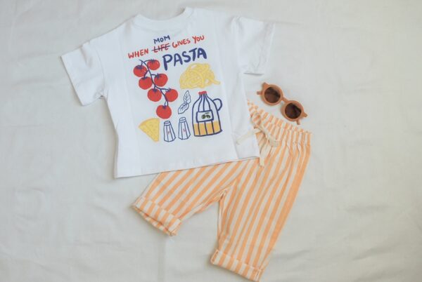 A childrens outfit with a white T-shirt featuring food drawings and the text Mom, when life gives you pasta, paired with orange-and-white striped pants and brown sunglasses, laid out on a white background.