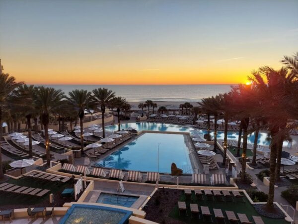 A view of the ocean and pool from a resort