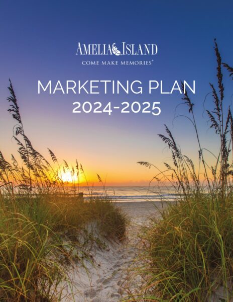 Pathway lined with tall grass leads to a sandy beach at sunrise or sunset, with Amelia Island Marketing Plan 2024-2025 and Come Make Memories text overlaid on the sky.