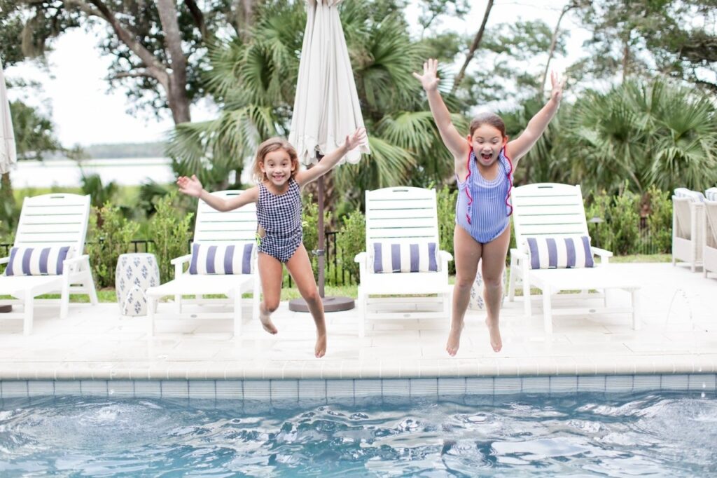 girls jumping into pool